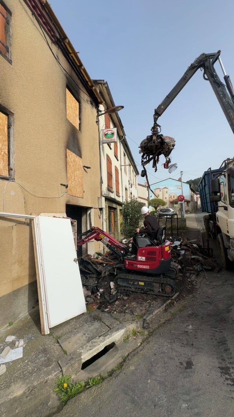 Mini-pelle et camion-grue à grappin évacuant les déchets après une démolition, à Puy-Guillaume